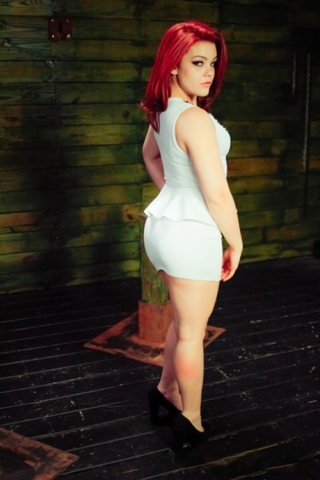 Redheaded submissive Kimber Woods gets banged by strapon lesbians in a dungeon 98022772