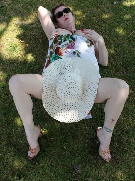 Mature amateur Mary Bitch pulls down her thong on a lawn in a sun hat 16754380