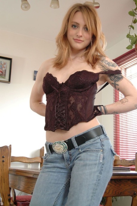 Tattooed girl Oro Mali stands naked after stripping in the dining room 98163277