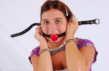 Clothed redhead fits herself with a ball gag while wearing handcuffs 91134908