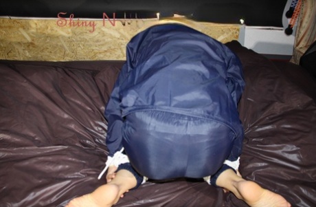 White girl struggles against her restraints while gagged in rainwear 56020602