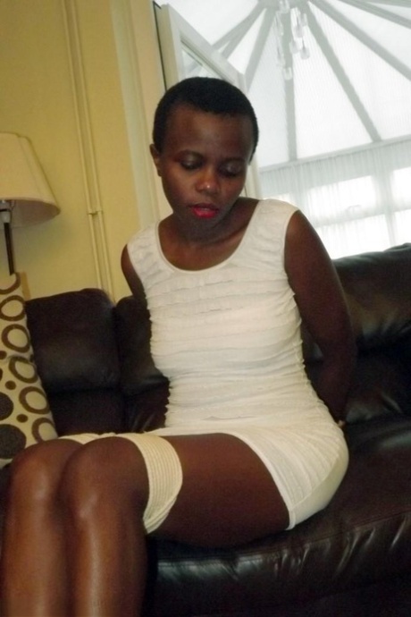 Black female is left tied and cleave gagged in a white dress on a leather sofa 65679458