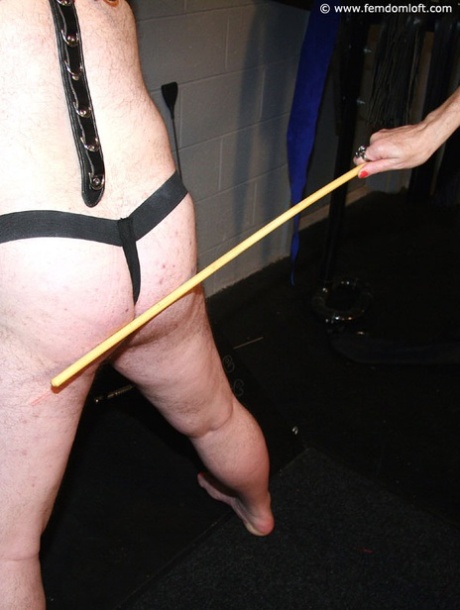 Mature lady dominates a submissive man up against a St Andrews Cross 55782169