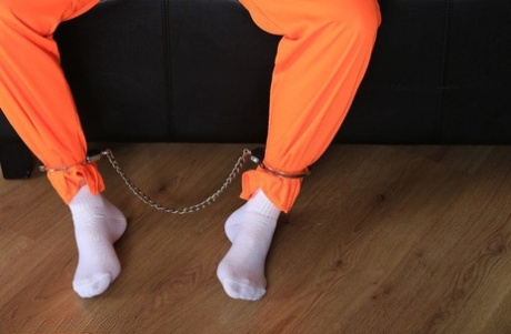 Female prisoner is left alone while cuffed in an orange jumper and white socks 34770536