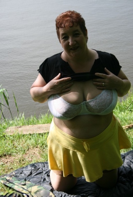 Older redhead Kinky Carol exposes her bra and underwear near the water 50041368