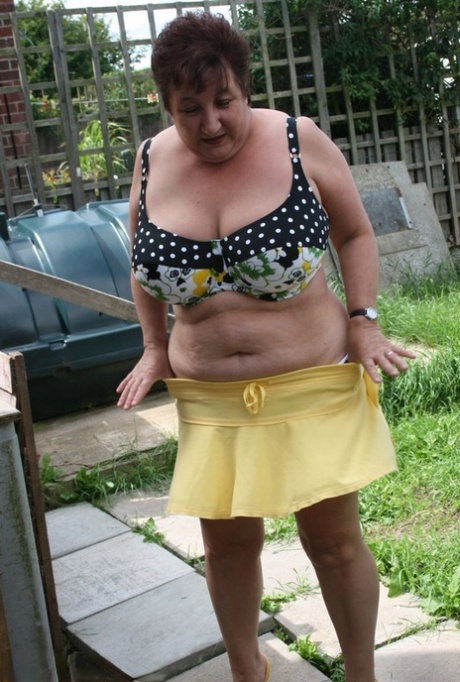 Thick older woman Kinky Carol models a bikini on patio stones 24784974