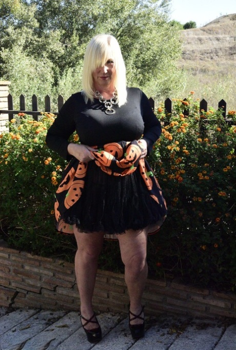 Mature blonde Melody exposes her bra and panties while dressed for Halloween 86047380