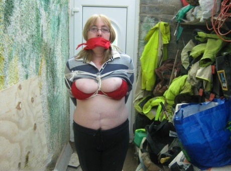 Mature woman is silenced with a gag while her tits are tied up with rope 96318862