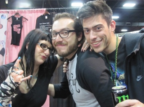 Tattooed alt models kiss and fool around during an XXX trade show 99757019